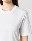 A person wears the BUNDLE X 50 Stanley/Stella Creator 2.0 T-Shirts With Free DTG Print by MyNeedsAreSimple in plain white, shown from shoulders to chest against a plain background.