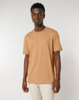 A man wearing a tan STTU169 Stanley/Stella Creator 2.0 The Iconic Unisex T-Shirt.