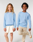 A boy and girl in matching STSK181 Stella/Stella Mini Changer 2.0 The Iconic Kids’ Crew Neck Sweatshirt outfits.