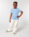 A young girl in a Stanley/Stella Organic Cotton T-shirt and white pants.