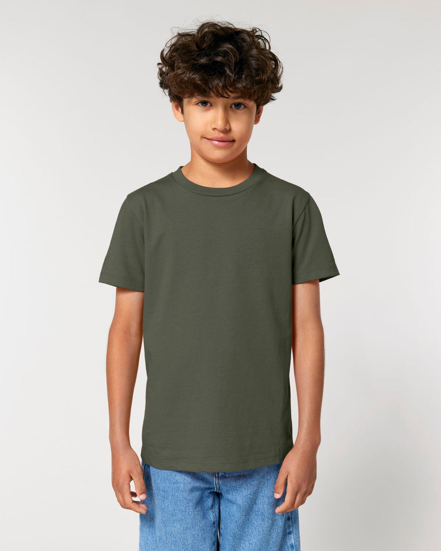 A boy wearing a green STTK184 Stella/Stella Mini Creator 2.0 The Iconic Kids’ T-shirt.