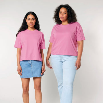 Two women wearing STTW175 Stella Nova organic cotton pink t-shirts with a boxy fit and jeans stand side by side against a neutral background.