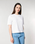 Woman wearing a STTW175 Stella Nova Womens Boxy T-Shirt and blue jeans standing against a light background.