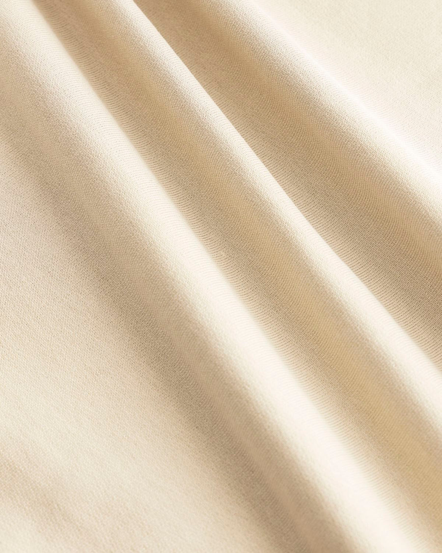 Sentence with replaced product name: Beige organic fabric with soft folds casting gentle shadows on the STTU169 Stanley/Stella Creator 2.0 The Iconic Unisex T-Shirt.
