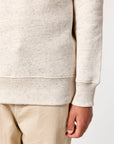 A man wearing a Stanley/Stella 100% cotton white sweatshirt and khaki pants.