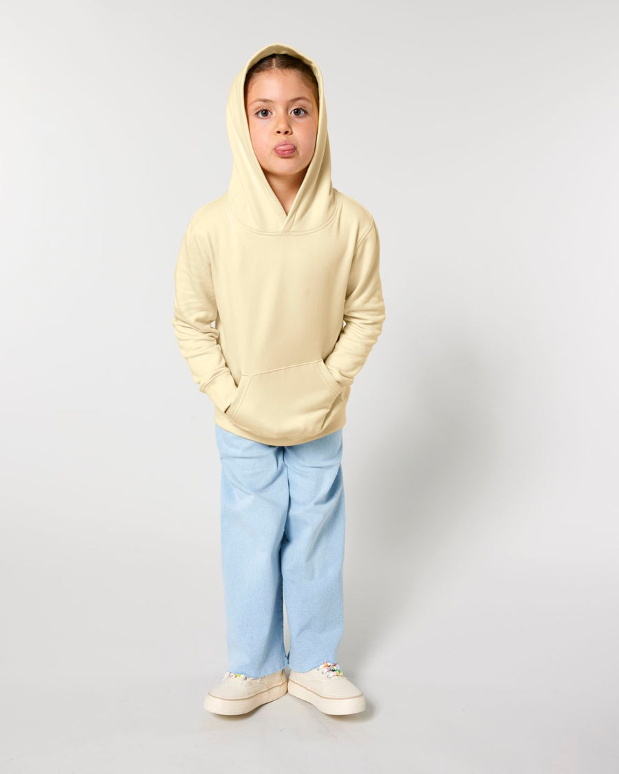 A young boy wearing a STSK180 Stella/Stella Mini Cruiser 2.0 The Iconic Kids Hoodie Sweatshirt and blue pants.