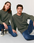 Two models in test demo STSU868 Stanley/Stella Roller Organic Cotton Essential Sweatshirts and blue jeans sitting side by side against a white background, showcasing My Needs Are Simple brand.