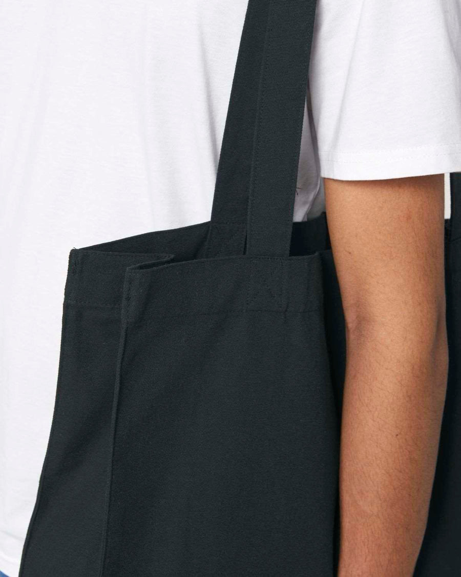 A Male model showcasing a black organic cotton woven shopping bag