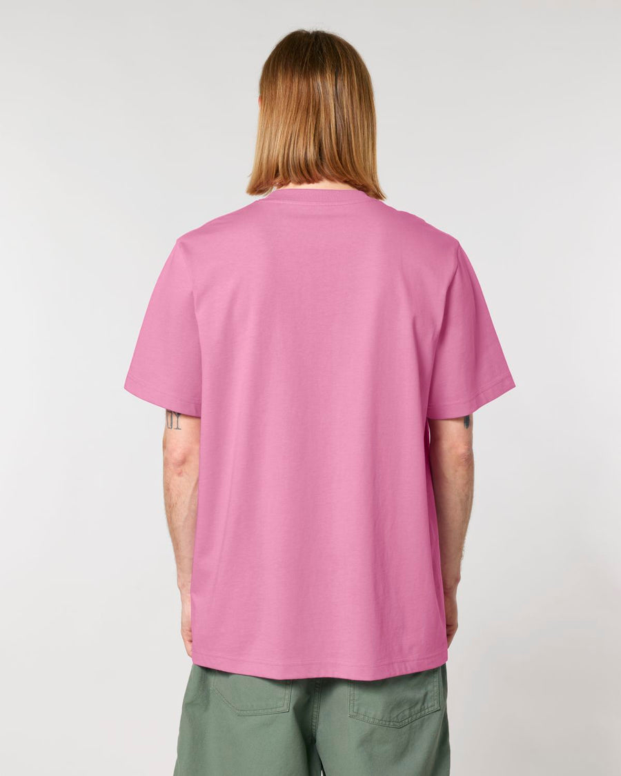 A person standing with their back to the camera, wearing a Stanley/Stella STTU171 Sparker 2.0 The Unisex Heavy T-Shirt in plain pink organic cotton and green trousers.