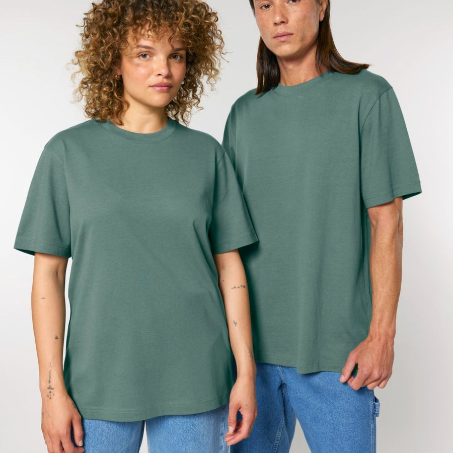 A man and woman wearing matching Stanley/Stella STTU171 Sparker 2.0 The Unisex Heavy T-Shirts, posing for a picture.
