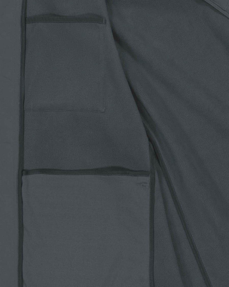 Close-up of a dark gray fabric showing details of pockets and stitching on a MyNeedsAreSimple STJM167 Stanley/Stella Navigator Men's Non-Hooded Softshell jacket.
