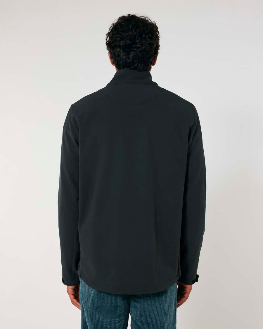 A man with curly hair, seen from the back, wearing a MyNeedsAreSimple STJM167 Stanley/Stella Navigator Men's Non-Hooded Softshell jacket and blue jeans against a plain white background.