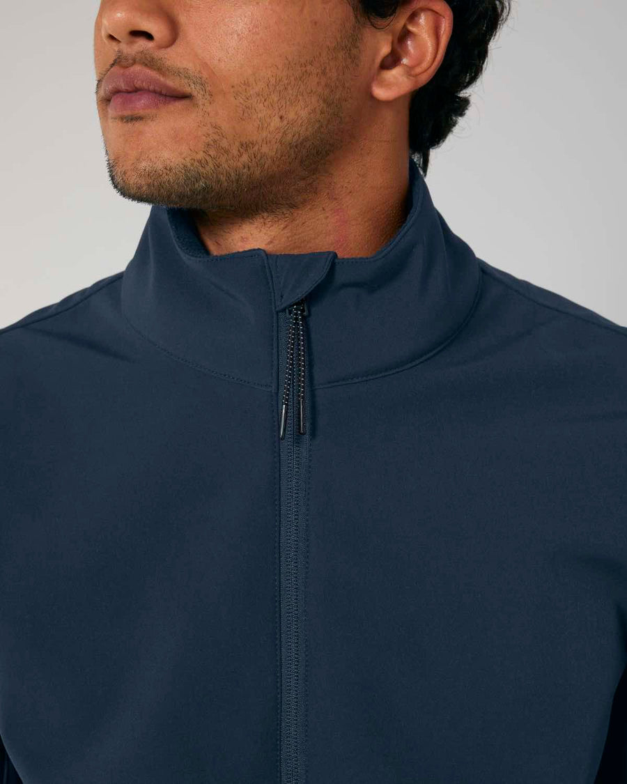 Close-up of a man wearing a dark blue MyNeedsAreSimple STJM167 Stanley/Stella Navigator Men's Non-Hooded Softshell jacket made of recycled polyester, with a high collar, focusing on the zipper and neckline.