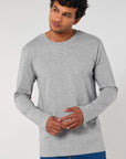 A man wearing a grey Stanley/Stella organic cotton long sleeve STTM560 Stanley Shuffler The Iconic Men's Long Sleeve T-Shirt.