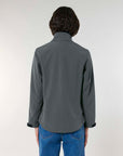 A man viewed from behind wearing a MyNeedsAreSimple STJW166 Stanley/Stella Navigator Women’s Non-Hooded Softshell shirt and blue jeans, standing against a neutral background.