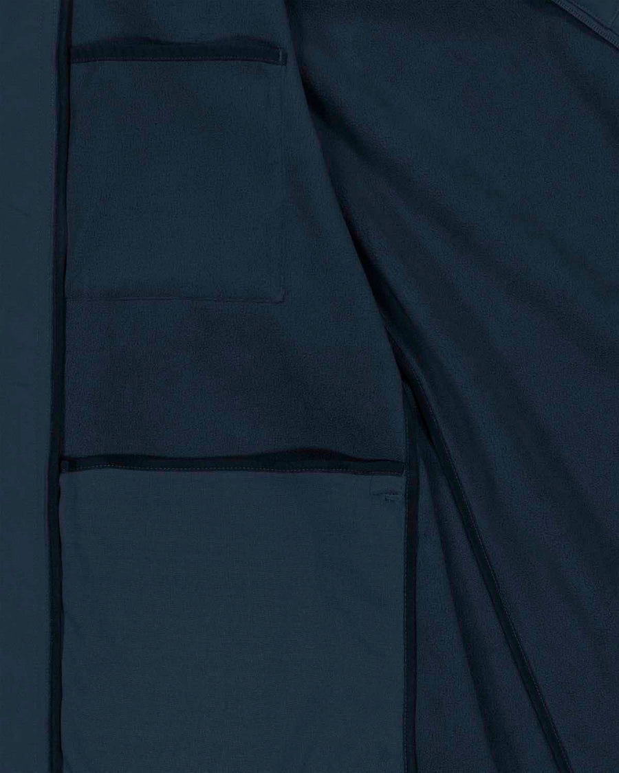 Close-up view of a dark blue MyNeedsAreSimple STJW166 Stanley/Stella Navigator Women’s Non-Hooded Softshell fabric with detailed stitching and pocket design, emphasizing texture and construction.