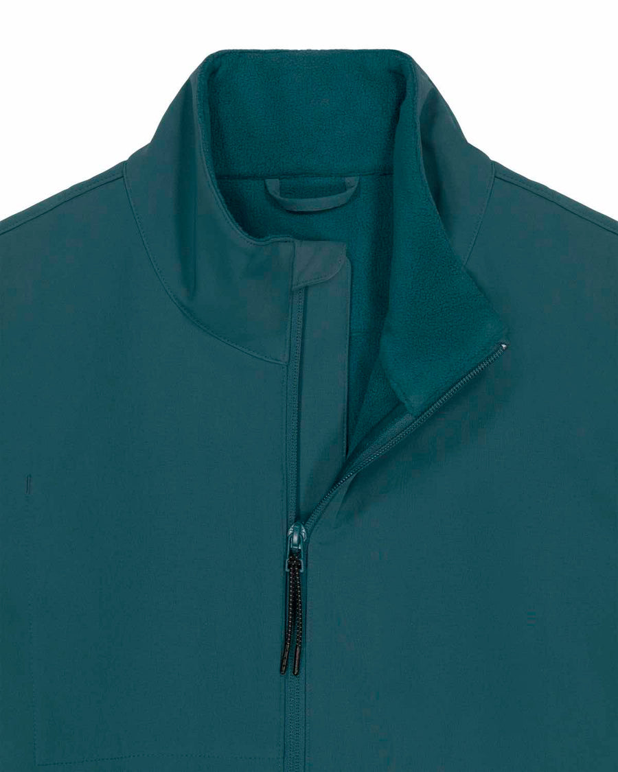 Close-up of a dark teal MyNeedsAreSimple Navigator Women’s Non-Hooded Softshell jacket with a raised collar and a partially unzipped front, showing fleece lining.