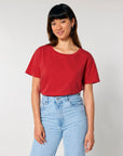 Woman wearing a red STTW173 Stella Serena Mid-Light scoop-neck t-shirt and blue jeans standing against a neutral background.