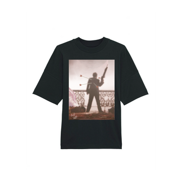 Black STTU815 Stanley/Stella Blaster Oversized High Neck Organic Cotton Unisex T-Shirt by Stanley/Stella, featuring a graphic of a silhouette holding a rifle and pierced by arrows, standing against a wrought iron fence at sunset.