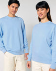 Two models wearing matching STSU178 Stella/Stella Changer 2.0 The Iconic Unisex crew neck sweatshirts made of organic cotton and cream pants.