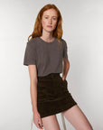 A woman wearing a Stanley/Stella Creator Vintage Unisex T-Shirt made of organic cotton and a corduroy skirt.