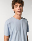 A young man wearing a Stanley/Stella Creator Vintage Unisex T-shirt made of organic cotton.
