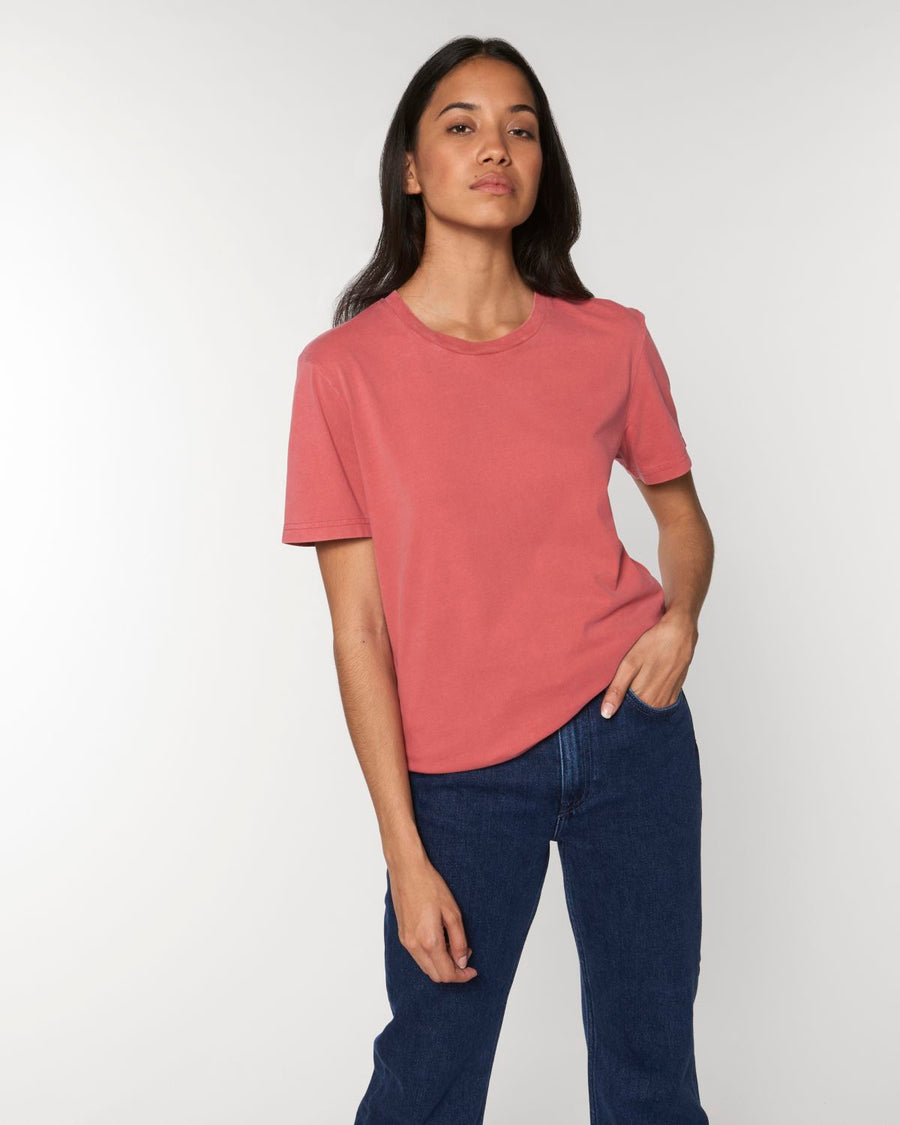 A woman wearing a pink Stanley/Stella Creator Vintage Unisex T-Shirt and jeans.