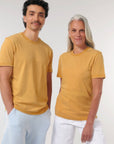 A man and a woman wearing yellow Stanley/Stella Creator Vintage Unisex T-shirts made from organic cotton.