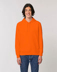 A man wearing a STSU812 Stanley/Stella Drummer Hoodie Bright Orange (C013).
