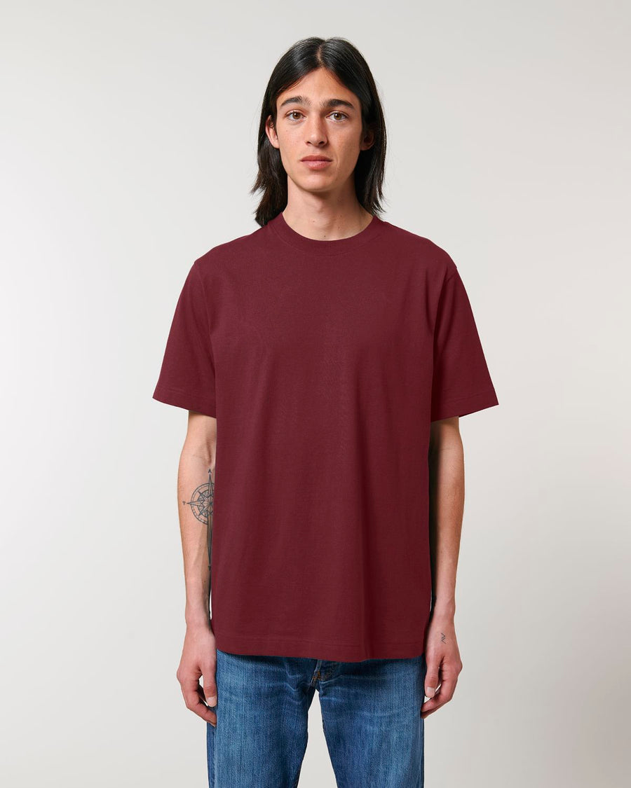 A man wearing a maroon STTU788 Stanley/Stella Freestyler Heavy Organic Cotton Unisex T-shirt and jeans.