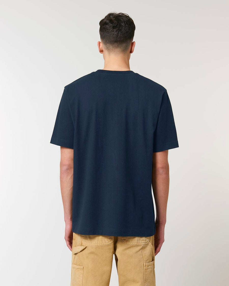 The back view of a man wearing a navy Stanley/Stella Freestyler Heavy Organic Cotton Unisex T-shirt and khaki pants.