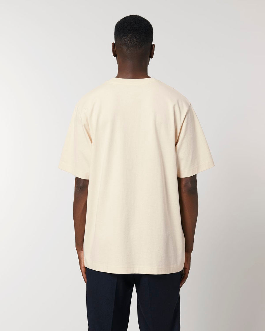 The back view of a man wearing a cream STTU788 Stanley/Stella Freestyler Heavy Organic Cotton Unisex T-shirt.