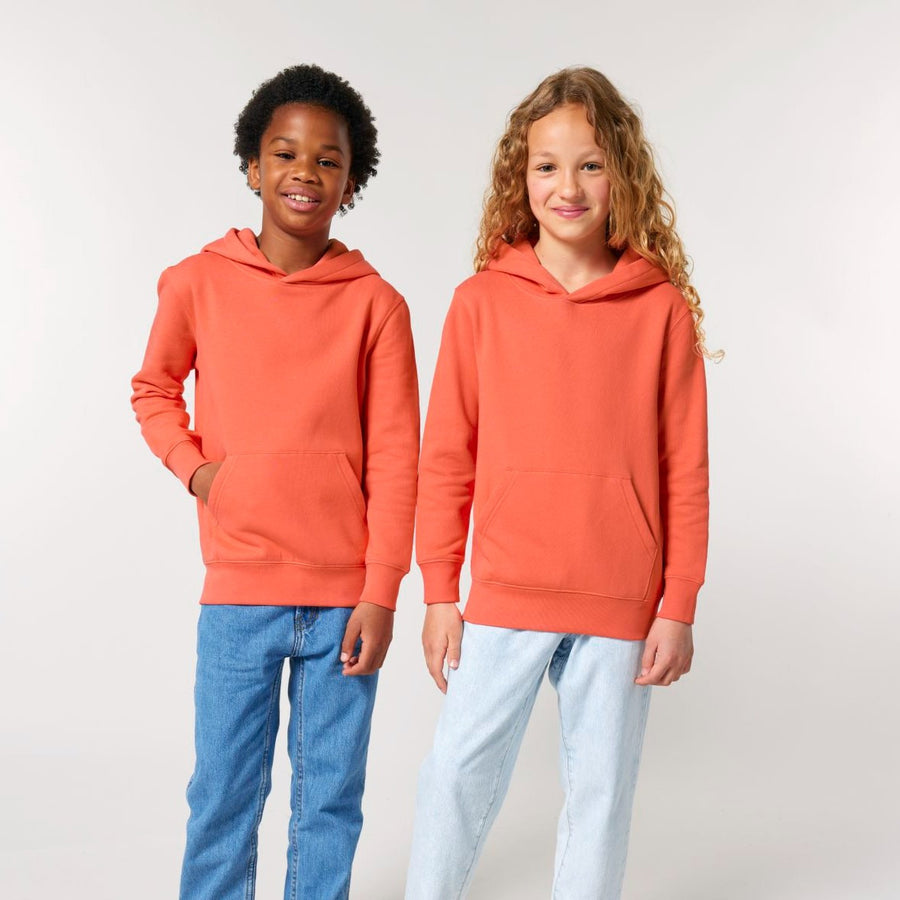 Two children wearing STSK180 Stella/Stella Mini Cruiser 2.0 The Iconic organic cotton kids' hoodie sweatshirts in orange with jeans.