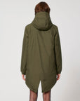The back view of a woman wearing a STJU841 Stanley/Stella Padded Parker Jacket in green.