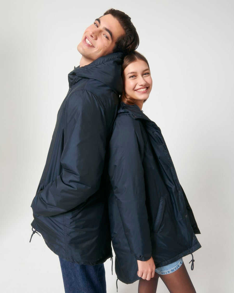 A man and woman are posing for a photo in a STJU841 Stanley/Stella Padded Parker Jacket by Stanley/Stella.