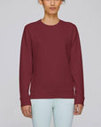A Stanley/Stella Rise eco-friendly Sweatshirt in burgundy worn by a female model