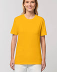A female model wearing an organic yellow Stanley/Stella rocker T-Shirt