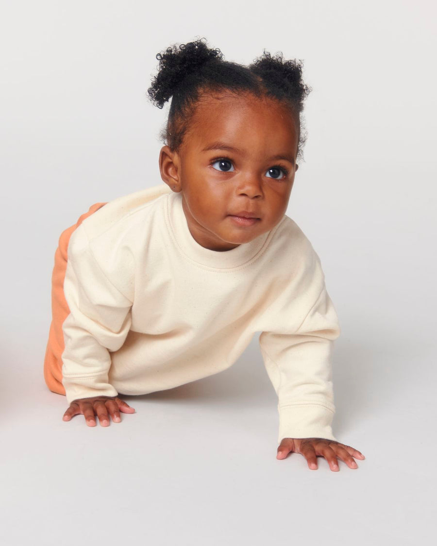 A baby crawling on the floor in a STSB920 Stella/Stella Baby Changer The Iconic Babies' Crew Neck Sweatshirt.
