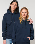 A man and a woman wearing a Stanley/Stella Slammer Heavy Relaxed Organic Cotton Unisex Hoodie.