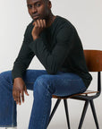 A male model wearing a black Stanley/Stella Shuffler organic cotton long sleeve T-Shirt
