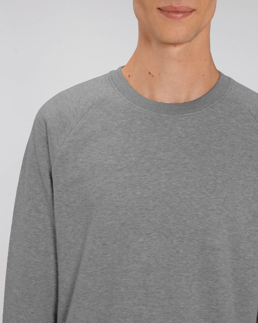 A male model wearing a heather grey Stanley/Stella Stroller eco-friendly cotton sweatshirt