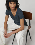 A female model wearing a Stanley/Stella Ladies dark heather denim evoker v neck T-Shirt