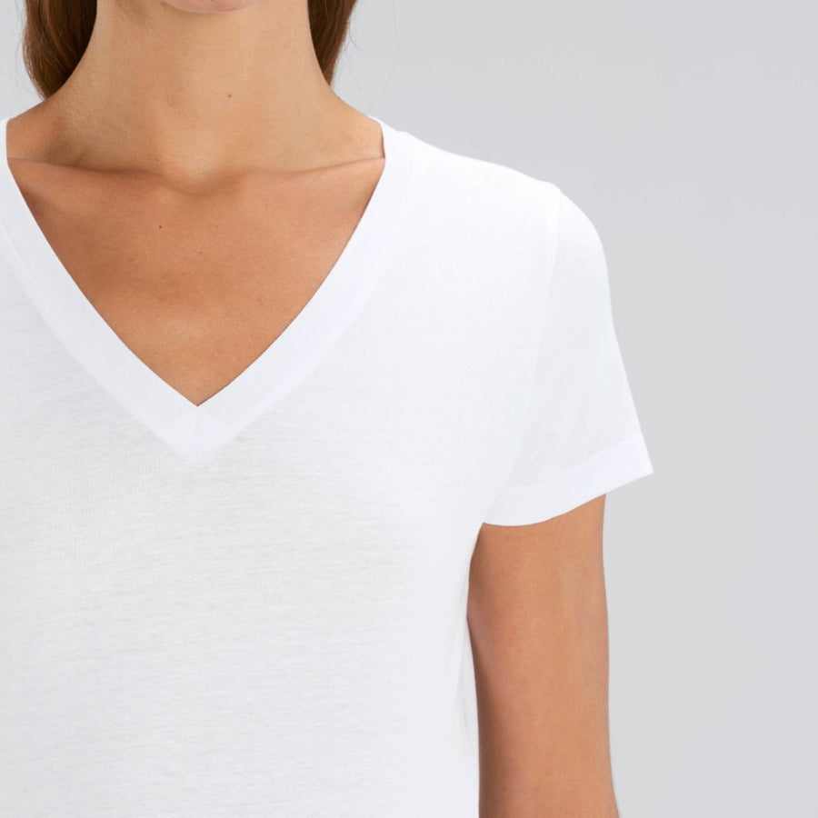 A front detail view of a female model wearing a Stanley/Stella Ladies white evoker v neck T-Shirt