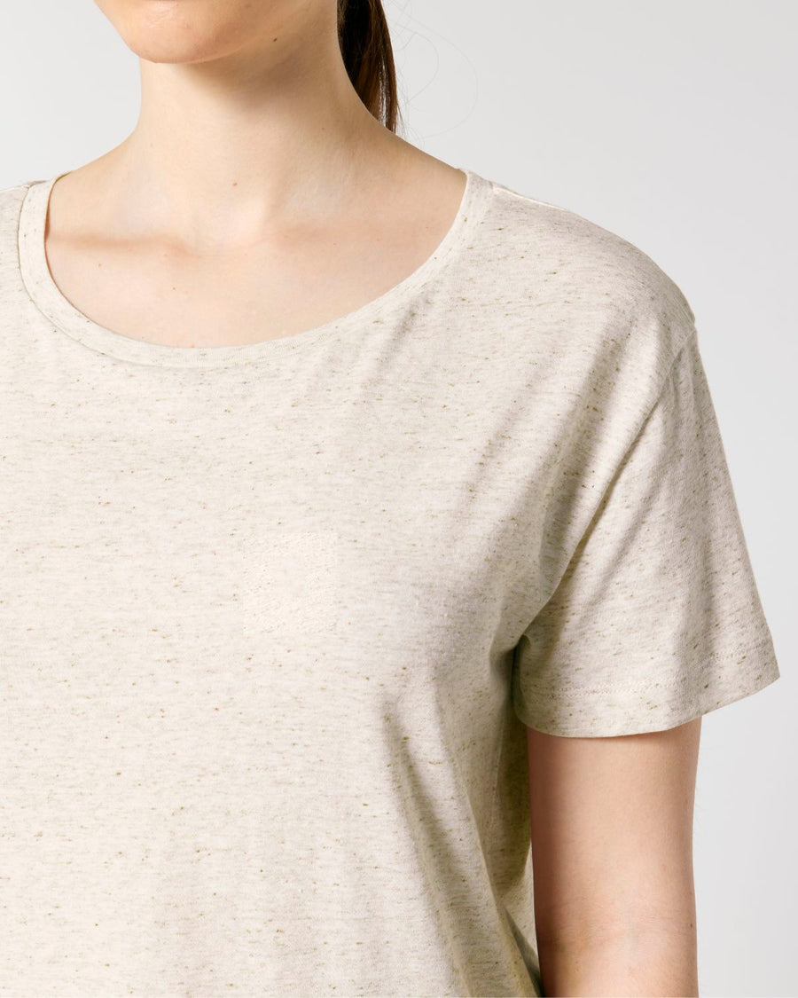 A person wearing a light beige STTW173 Stella Serena Mid-Light Scoop Neck T-Shirt by Stanley/Stella made from 100% Organic Cotton, photographed from the shoulders up against a plain background.